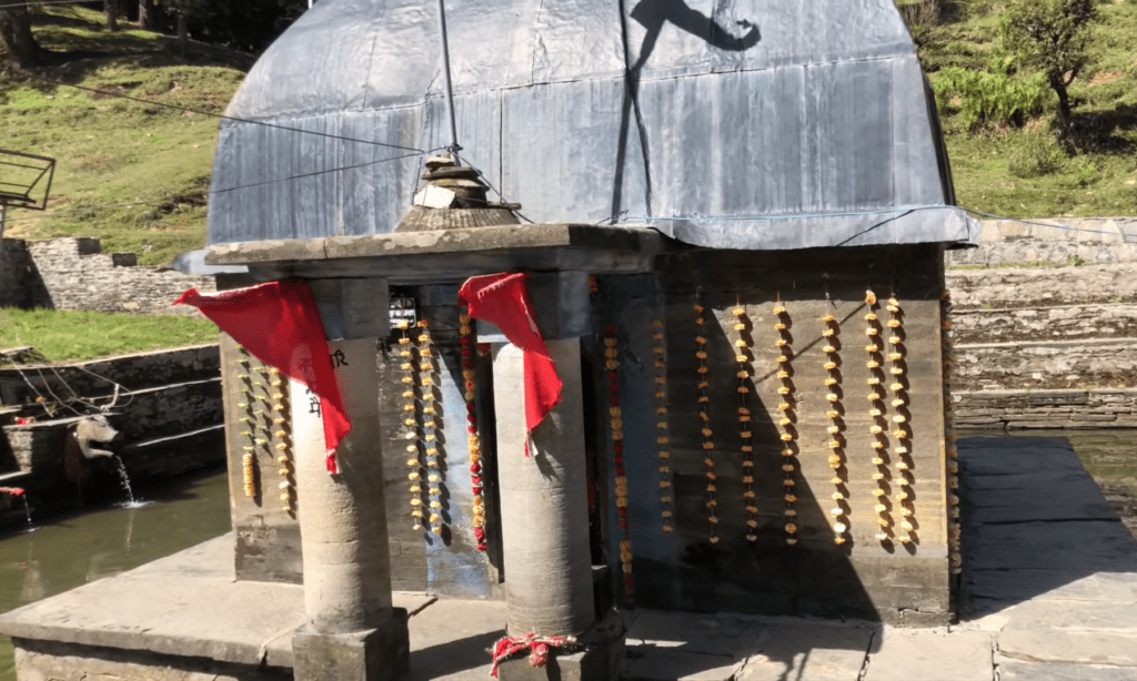 a giri ganga temple with a dome and a red flag