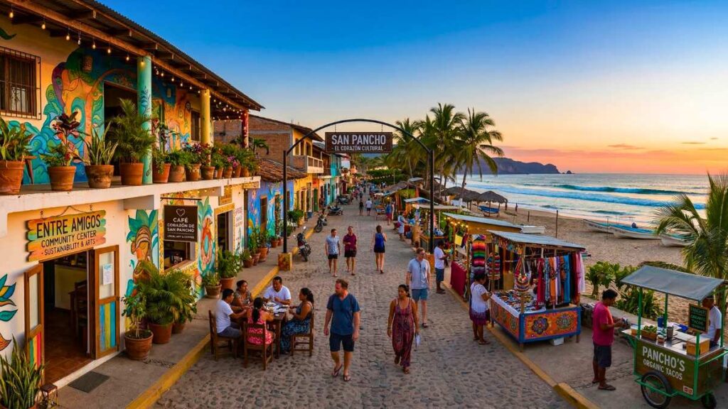 A vibrant street scene in San Pancho, Mexico at sunset. Colorful shops line the cobblestone path, with people dining and browsing market stalls by the ocean.